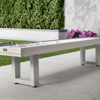 American Heritage Lanai 9' Outdoor Shuffleboard Table in Pearl White on a patio with greenery.